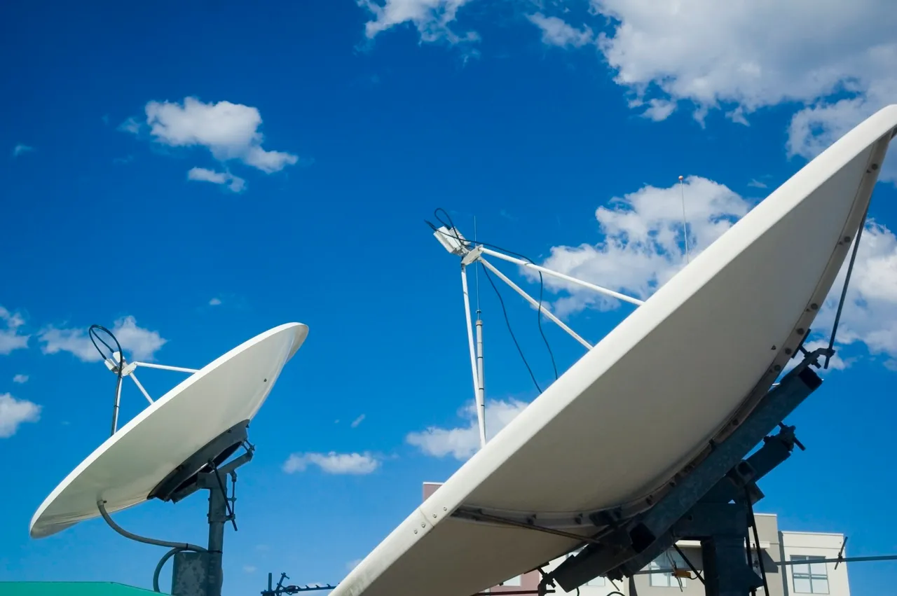 Dos antenas parabólicas de comunicaciones recortadas contra un cielo azul